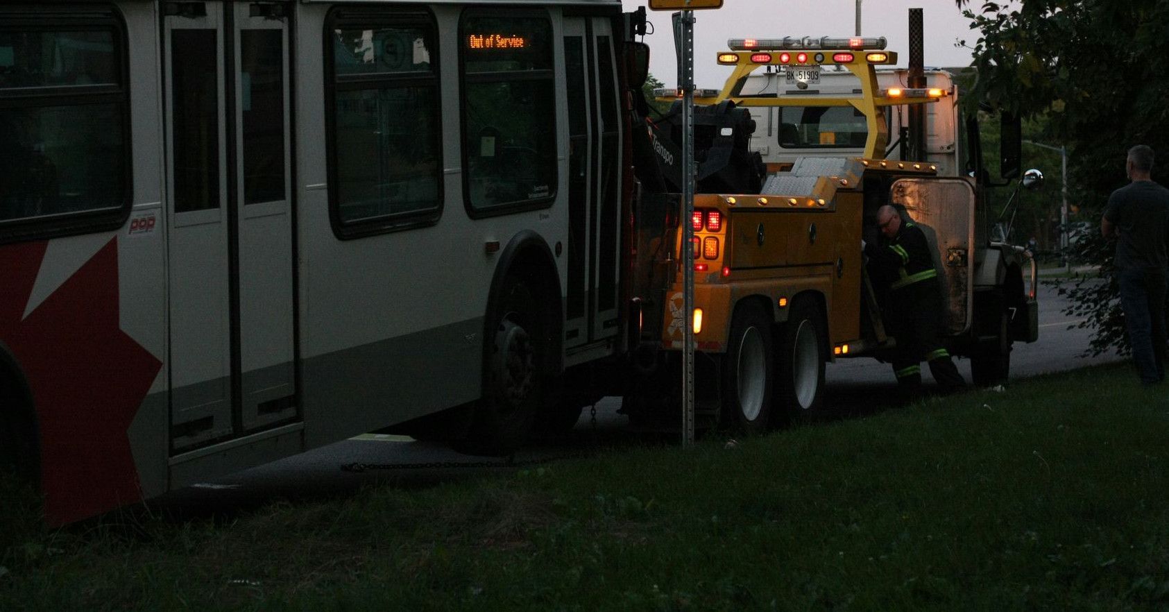 A tow truck towing a bus down a street